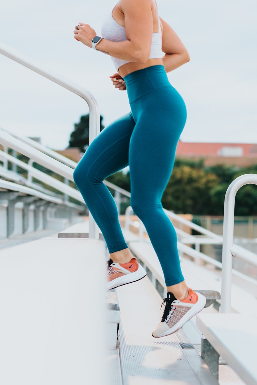 Active athlete walking and running up stadium steps for high calorie burn