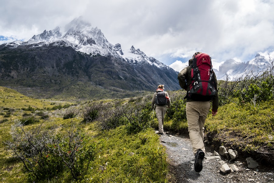Person hiking uphill on a vibrant mountain trail at sunrise